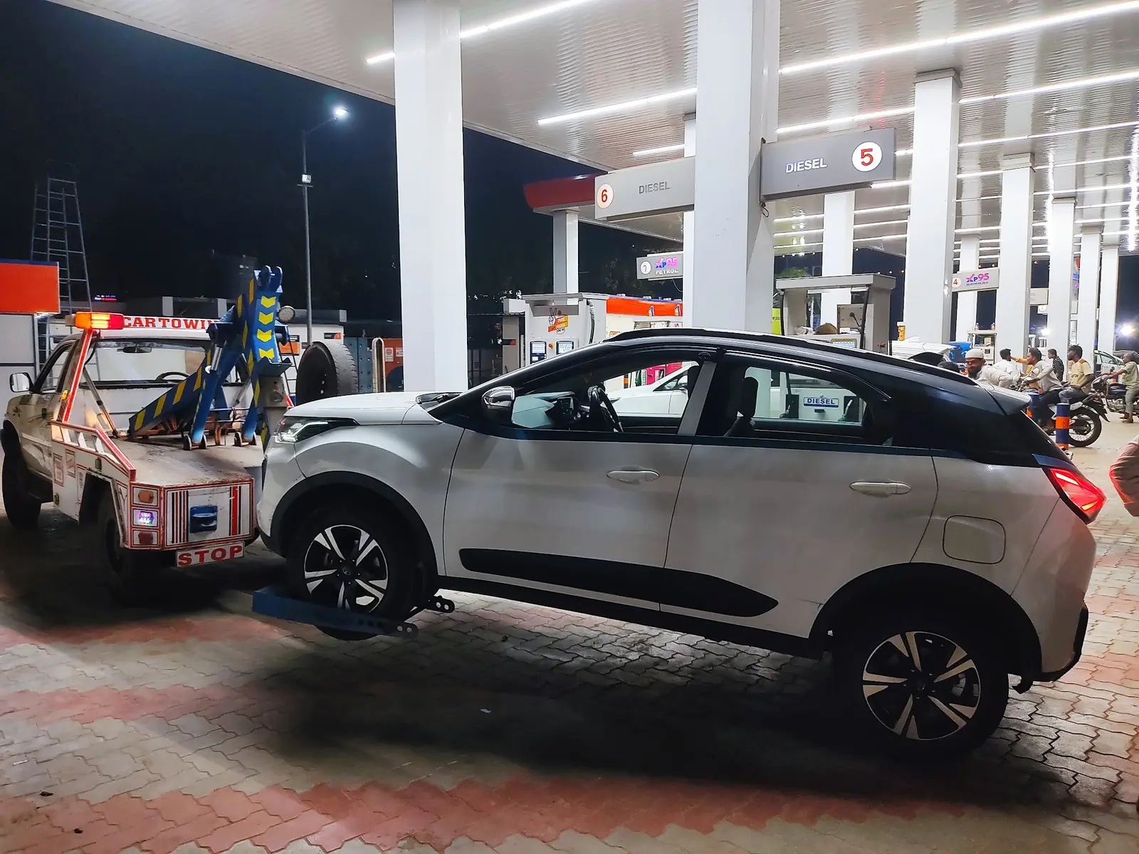 Car being towed at a petrol pump at night in Hyderabad