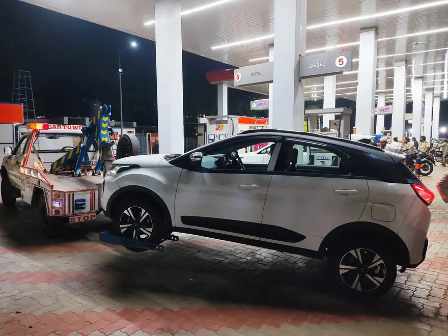 Car being towed at a petrol pump at night in Hyderabad