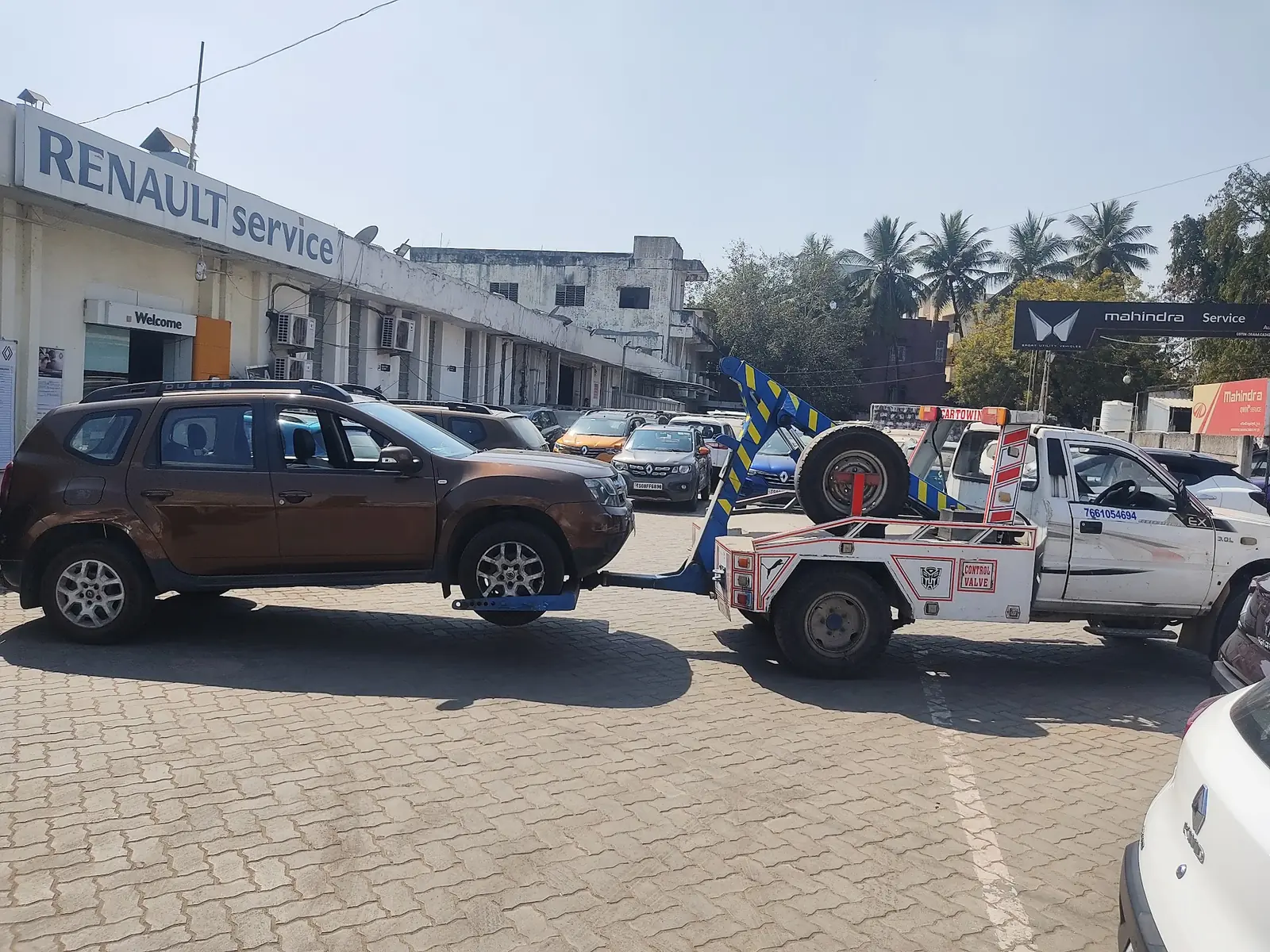 Car Towing Service tow truck delivering a vehicle at a Renault service centre in Hyderabad