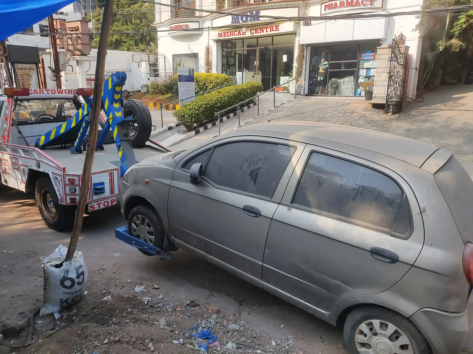 Tow truck picking up a car outside a medical centre in Hyderabad